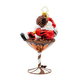 Christmas ornament of Santa Claus in a martini glass with a candy cane stick on a white background