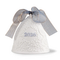 A white ceramic Christmas bell ornament with embossed floral patterns, featuring the year '2026' in silver on the front and a sheer silver-gray ribbon bow tied above it, set against a plain white background.