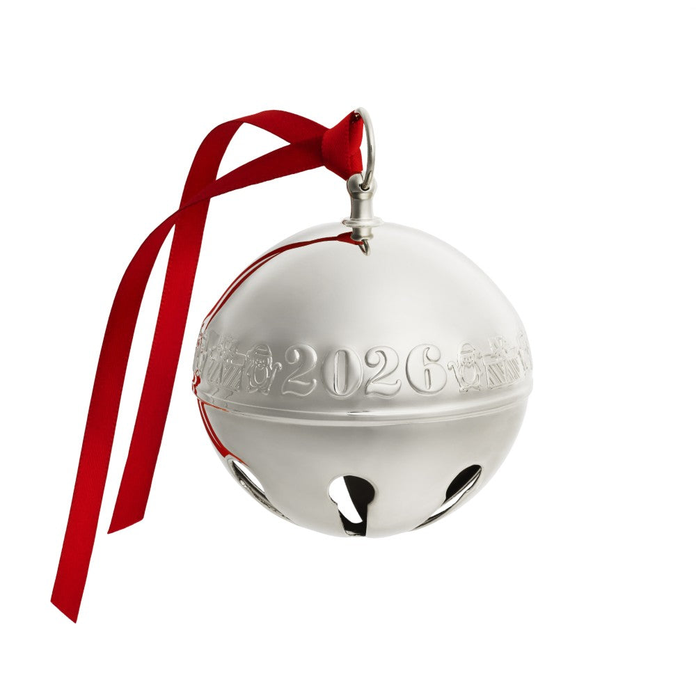 A shiny silver Christmas bell ornament with a red ribbon hanger, featuring the year '2026' embossed on the front, set against a plain white background.