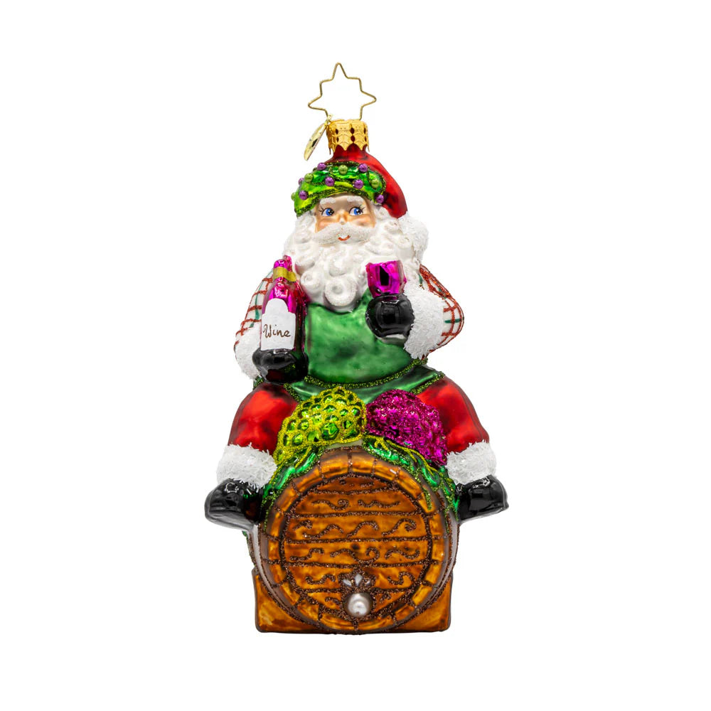 Decorative Christmas ornament of a colorful Santa Claus sitting on a barrel.