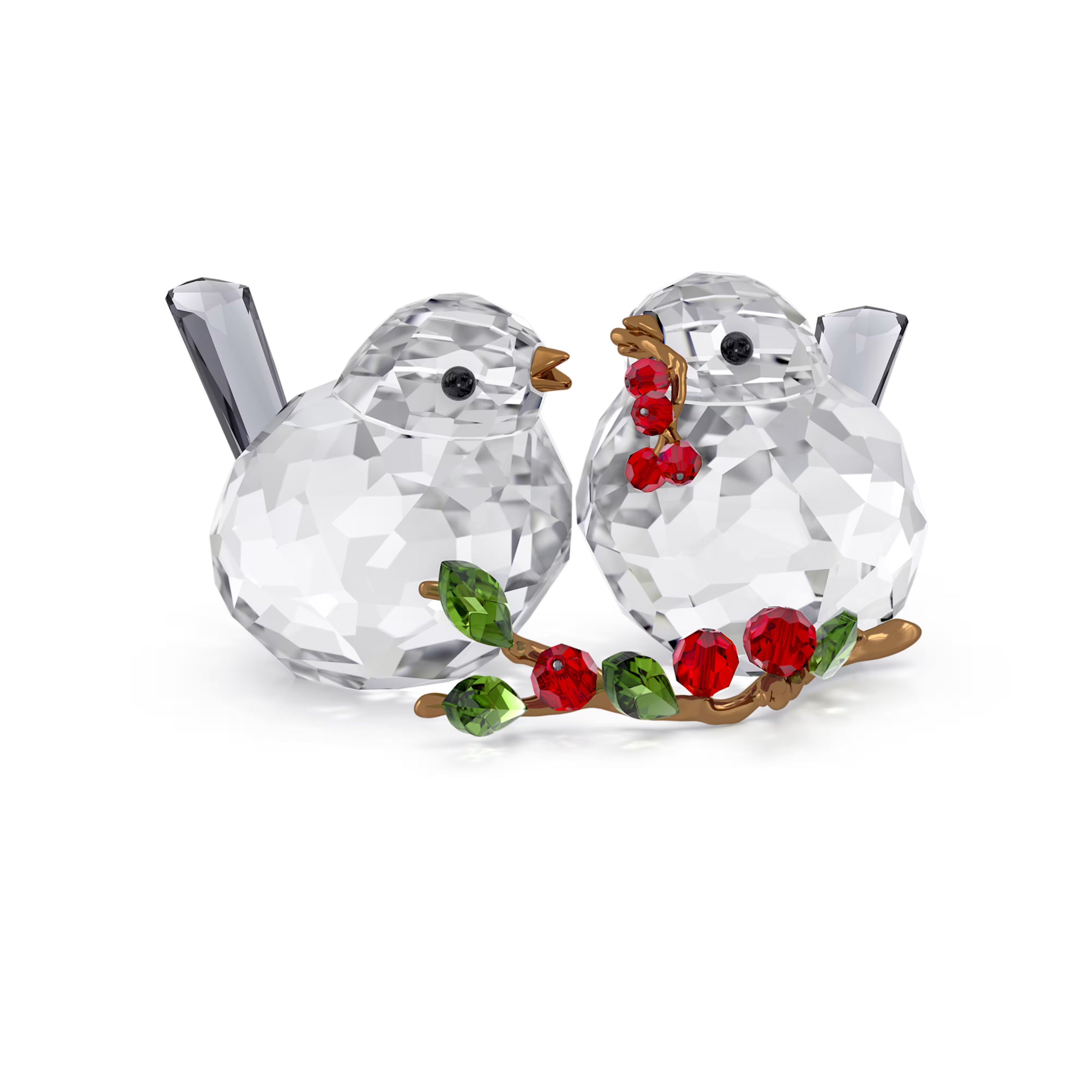 Crystal bird figurines with red berries on a branch against a white background