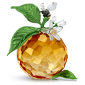 A crystal figurine of a clementine with a matte-finished blossom and a glossy metal bee on top, all in multicolored tones.